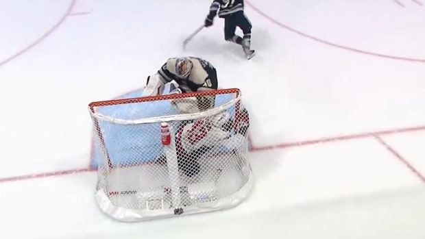 Blue Jackets goalie Elvis Merzlikins pushes Capitals forward Tom Wilson into the net during a game.